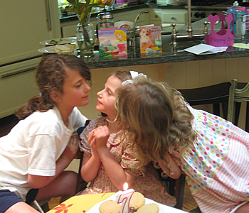 Alix and Lilly give Sarah a birthday kiss