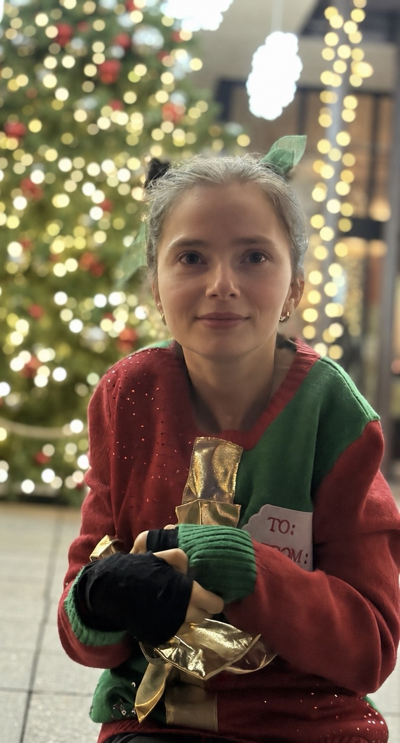 Sarah in front of a Christmas tree
