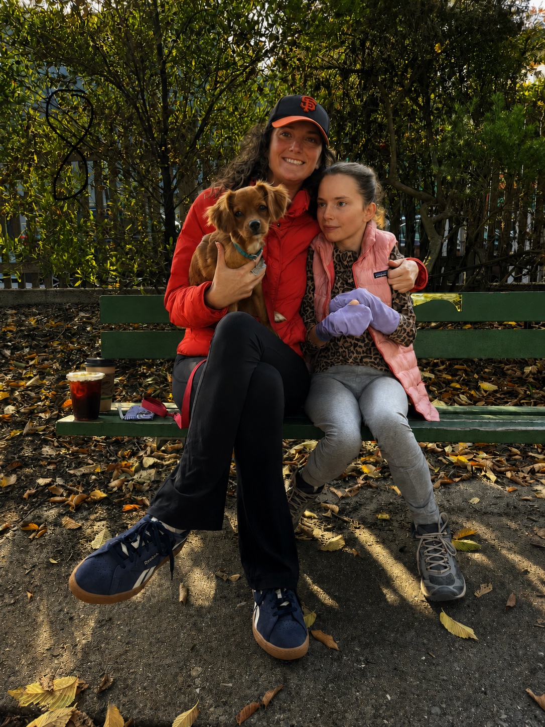Sarah and Alex sitting with Stanley on a park bench