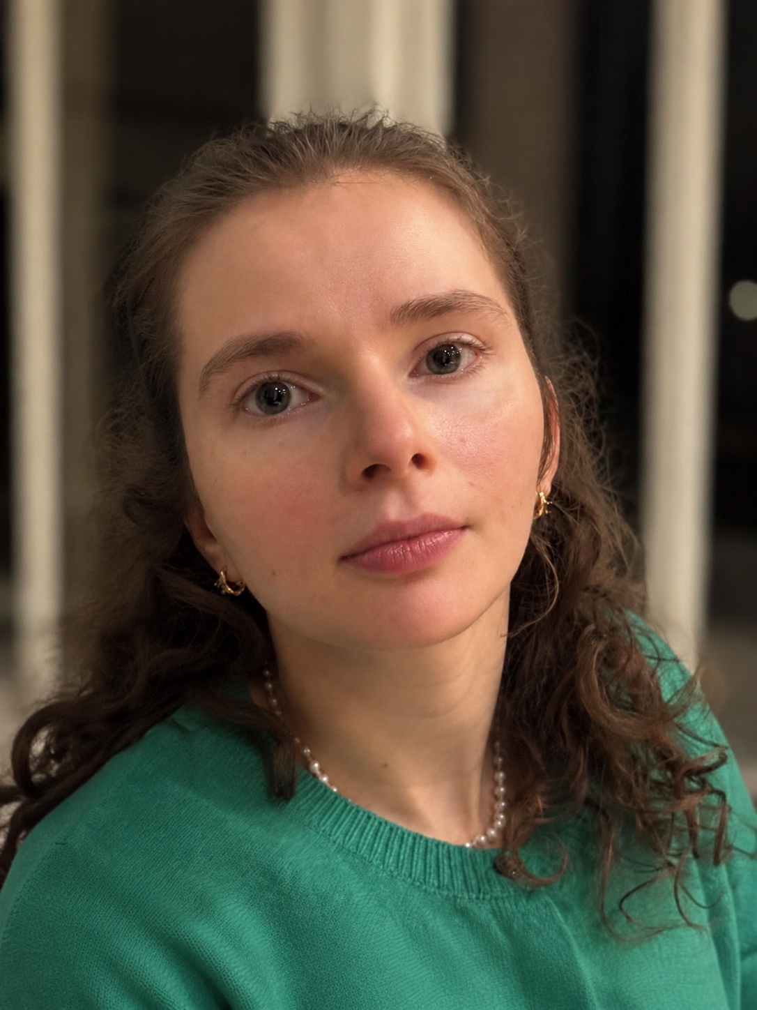 Centered portrait of Sarah wearing a green sweater