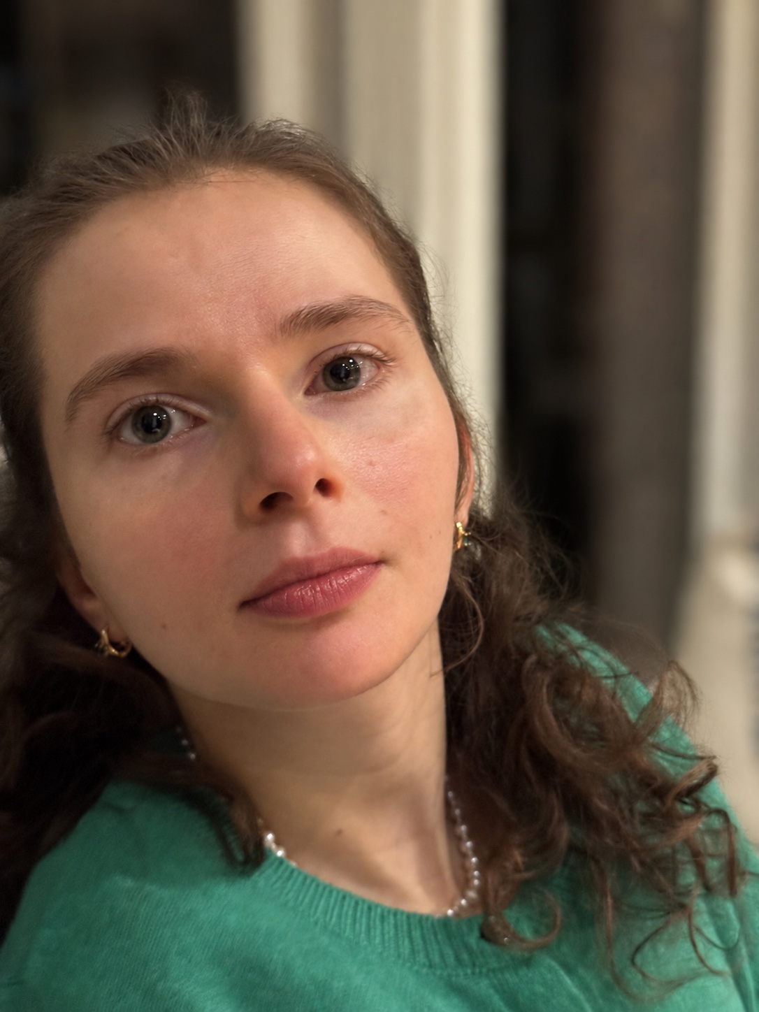 Close-up portrait of Sarah wearing a green sweater