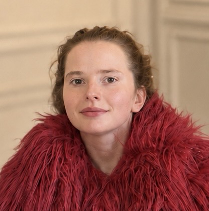 Portrait of Sarah wearing a deep red feathered wrap