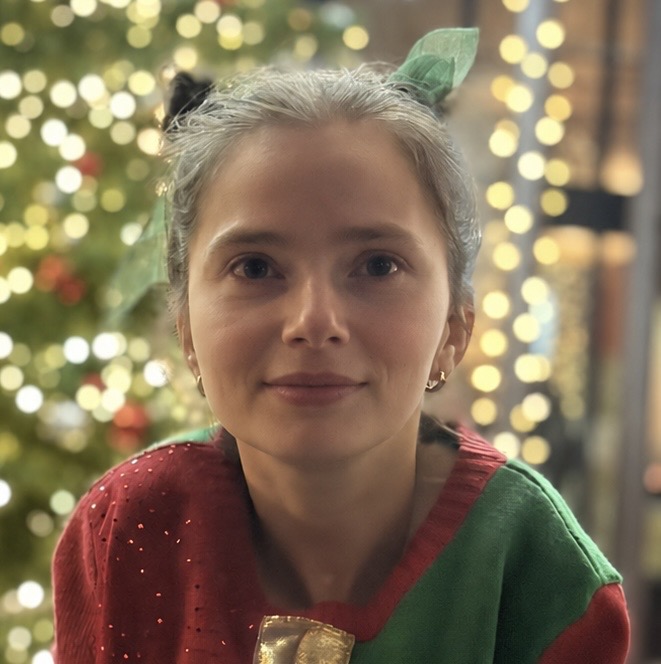 Sarah smiling in front of Christmas lights